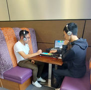 Two male friends learning how to DJ at a workshop 
