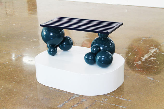 “Saturday” is a sculptural bench, a testament to the artist’s longing for rest and rejuvenation. Designed to embody the spirit of leisure, this artwork invites viewers to embrace the joy of intentional stillness and relaxation. The bench’s composition is both imaginative and unconventional: the bench top rests freely on a bubble-shaped base, creating an intentional sense of instability. This design choice prompts users to engage with the bench in a deliberate manner, fostering a heightened awareness of the act of resting. While “Saturday” is functional, it is intentionally not designed for abrupt or forceful movements. This deliberate instability serves as a reminder that true rest requires a gentle, intentional approach, underscoring the artist’s vision of creating a space for contemplation.
An added layer of depth is woven into the bench’s creation timeline. Designed and crafted after the artist’s experience of giving birth to her first child, “Saturday” encapsulates the transformative journey of motherhood. This intimate connection infuses the artwork with a sense of renewal, growth, and the discovery of new dimensions of self. The playful design of “Saturday” in both form and color evokes the spirit of a beloved toy. Its whimsical shape and vibrant hues are reminiscent of carefree childhood moments, capturing the essence of Saturdays—often associated with unstructured play and leisure. “Saturday” invites viewers to find delight in the act of resting, to rediscover the magic of leisure, and to immerse themselves in the playful and transformative encounter that this sculptural bench provides.