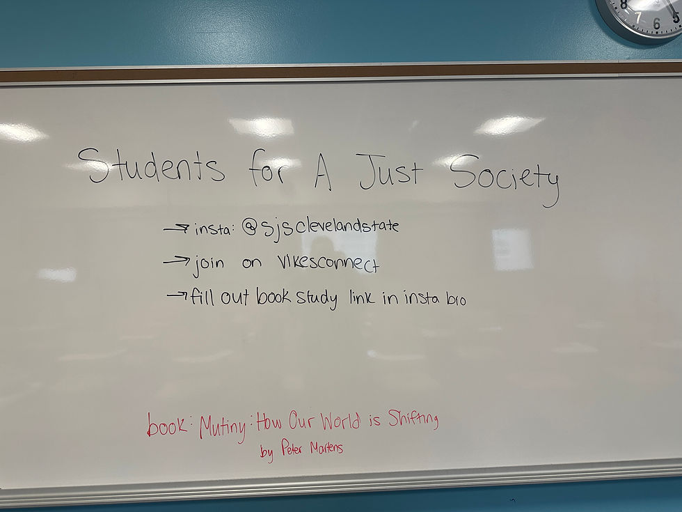 Whiteboard with "Students for A Just Society" text. Includes instructions for Instagram and VikesConnect, and a book study link. Blue wall background.