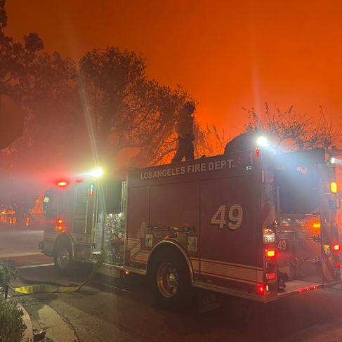 Firetruck among the orange, flame-lit sky.