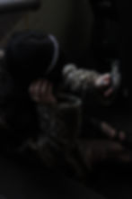 Woman in leopard print coat sits on stairs, holding a shiny compact mirror. She wears a headband and has dark, wavy hair.