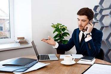 young-successful-businessman-speaking-phone-office-background.jpg