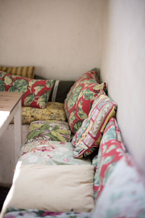 banquette de ciment recouverte de coussins de tissu multicolore