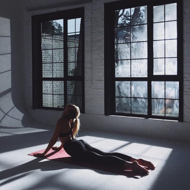 Karlie Kloss is performing cobra pose.