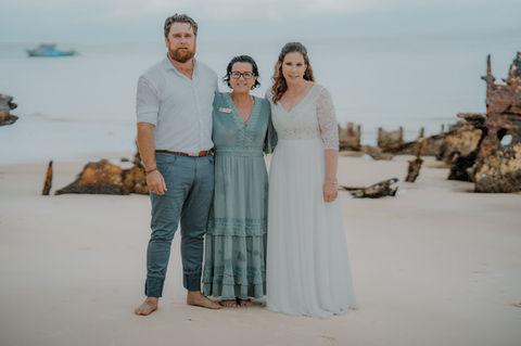 Kerri and her couple standing in front of Bulwer Wrecks on Moreton Island in the rain