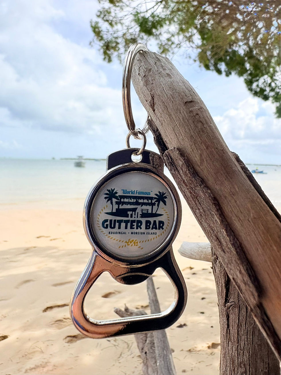 Close up of The Gutter Bar keychain bottle opener Moreton Island on a log