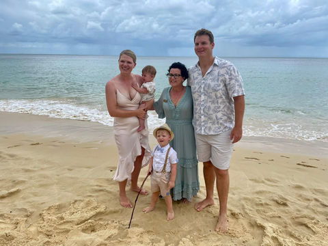 Kerri and a family standing at Tangalooma after a short and sweet wedding ceremony