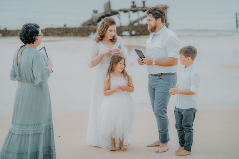 Kerri and her couple and their two kids standing in front of Bulwer Wrecks on Moreton Island