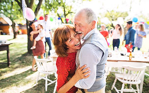 A senior couple dancing on a garden party outside in the backyard..jpg