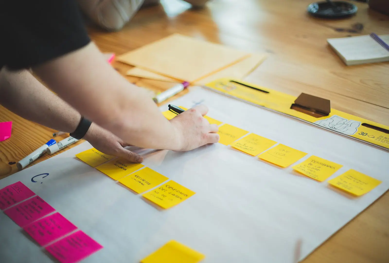 Person writing on a series of sticky notes