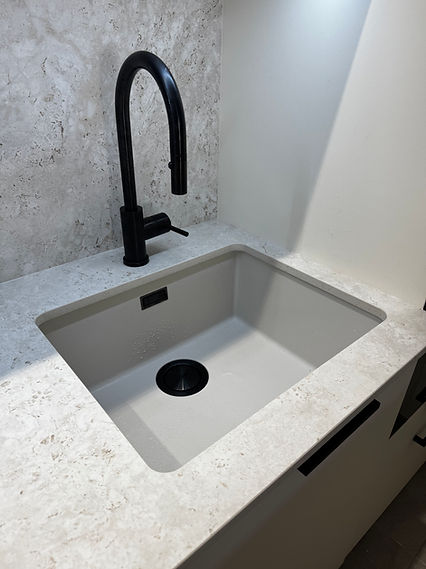 Évier sous plan et robinetterie noire intégrés au plan de travail Dekton