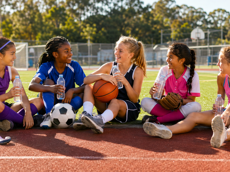 Diverse young female athletes from field hockey, soccer, basketball, softball and track resting together to show why recovery helps athletes grow stronger.