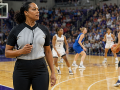 emale sports official confidently holding a whistle while overseeing a women’s athletic competition.