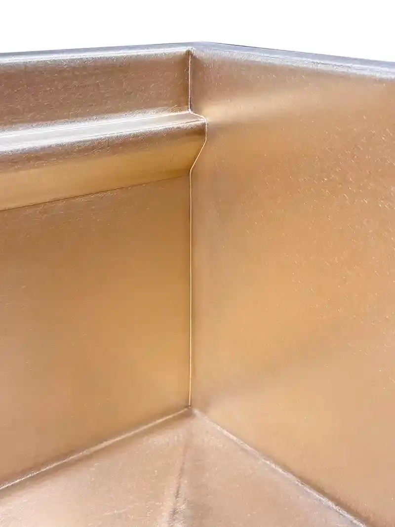 Close-up of MicroWelded interior corner on a custom solid bronze kitchen sink by Rachiele showing seamless micro-polished seam