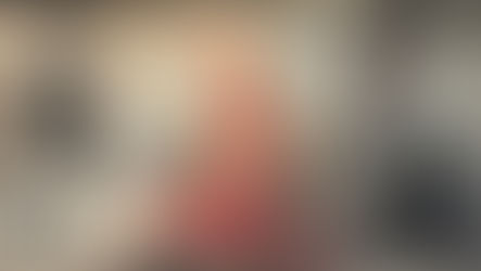 A woman sits against a wall covered in newspaper.