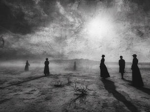 People stand in the desert searching the sky for the sun.
