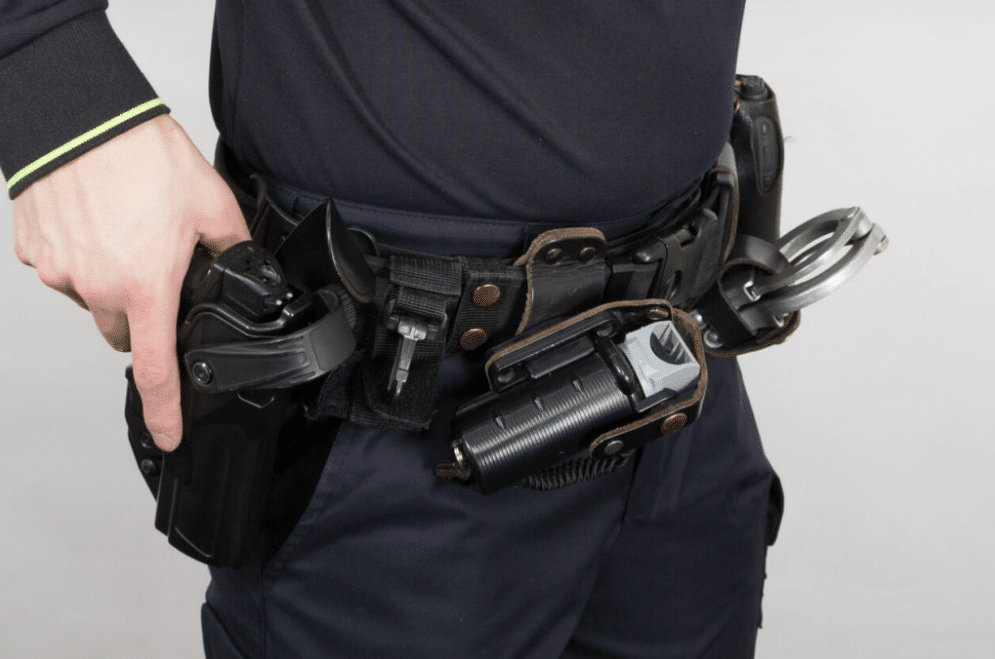 Armed-security-guard-with-his-hand-on-his-handgun-in-holster.webp