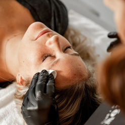 Brow technician at Lavoom Salon in Calgary applying eyebrow tint during a brow‑tinting service.