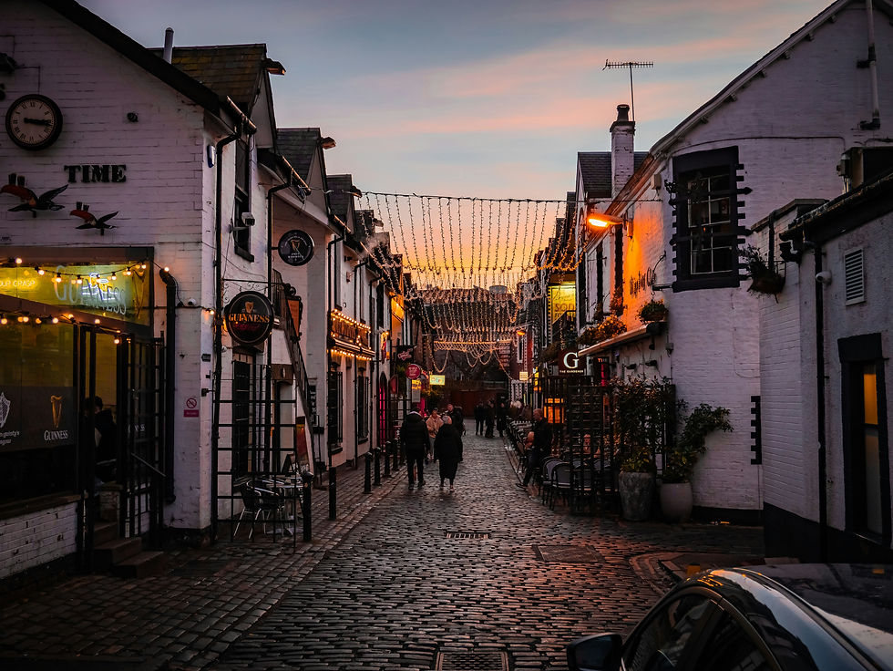 people walking on cobbled street in scotland