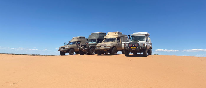 Four Land Cruiser on sand dune