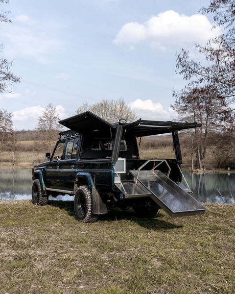 Schwarzer Geländewagen mit offener Ladefläche am See
