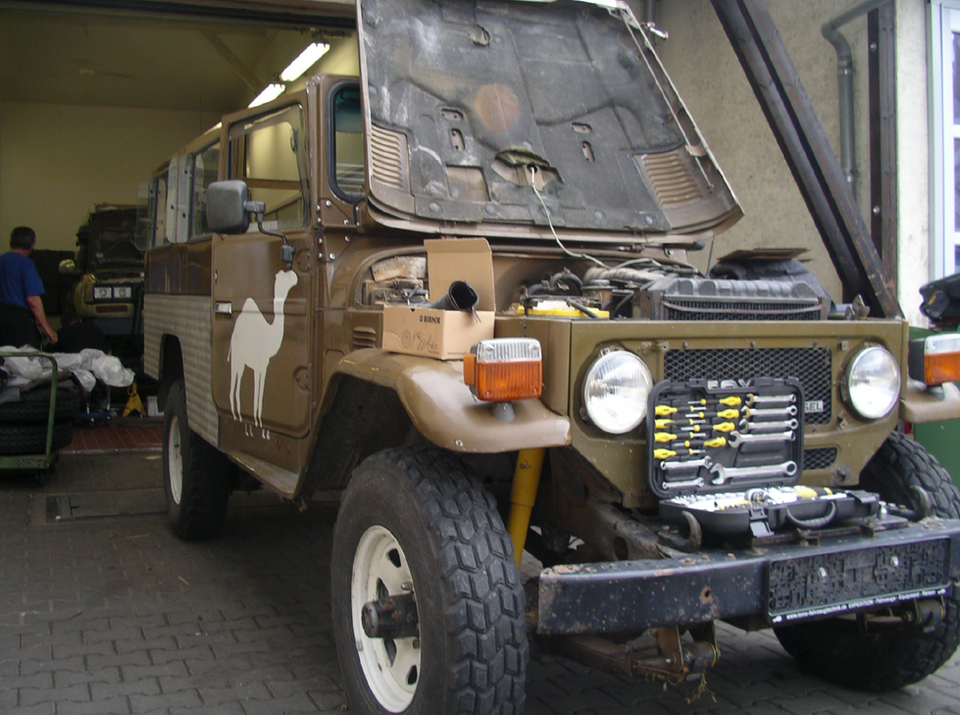 Offroad-Fahrzeugreparatur: Toyota Land Cruiser im Kamel-Design