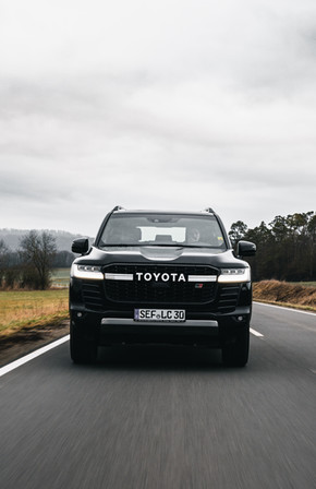 Schwarzer Toyota fährt auf Landstraße