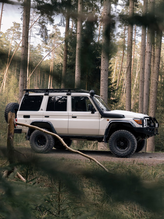 Weißer Toyota Land Cruiser im Wald