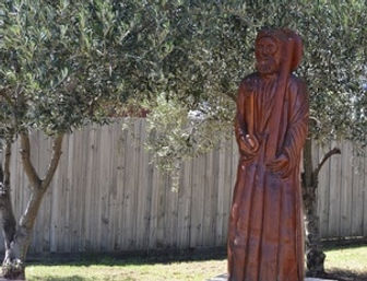 Statue of St Peter standing among olive trees