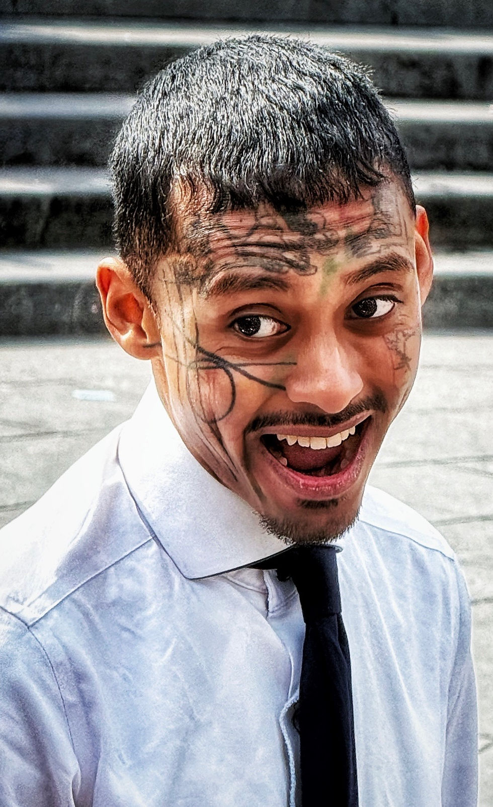 Someone doodled on his face like it was a cocktail napkin. Not the wisest of life choices, kid.