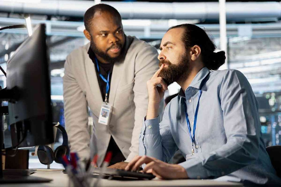 Two IT professionals are working together on a computer during server analysis in a modern data center environment.