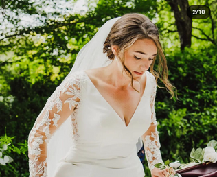 Bride in a white wedding dress, looking down, floral sleeves, arriving in carriage