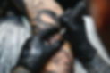 Cropped close up of a bearded tattoo artist working at his studio tattooing sleeve on the