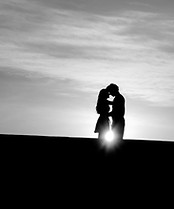 man and woman's silhouette on hill durin