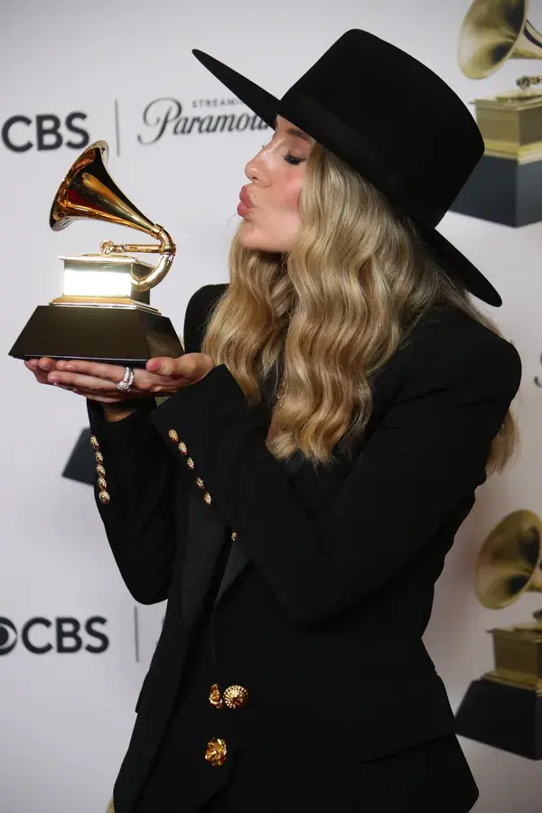 Lainey Wilson proudly poses with her GRAMMY award, celebrating her big win at the 2024 GRAMMYs.