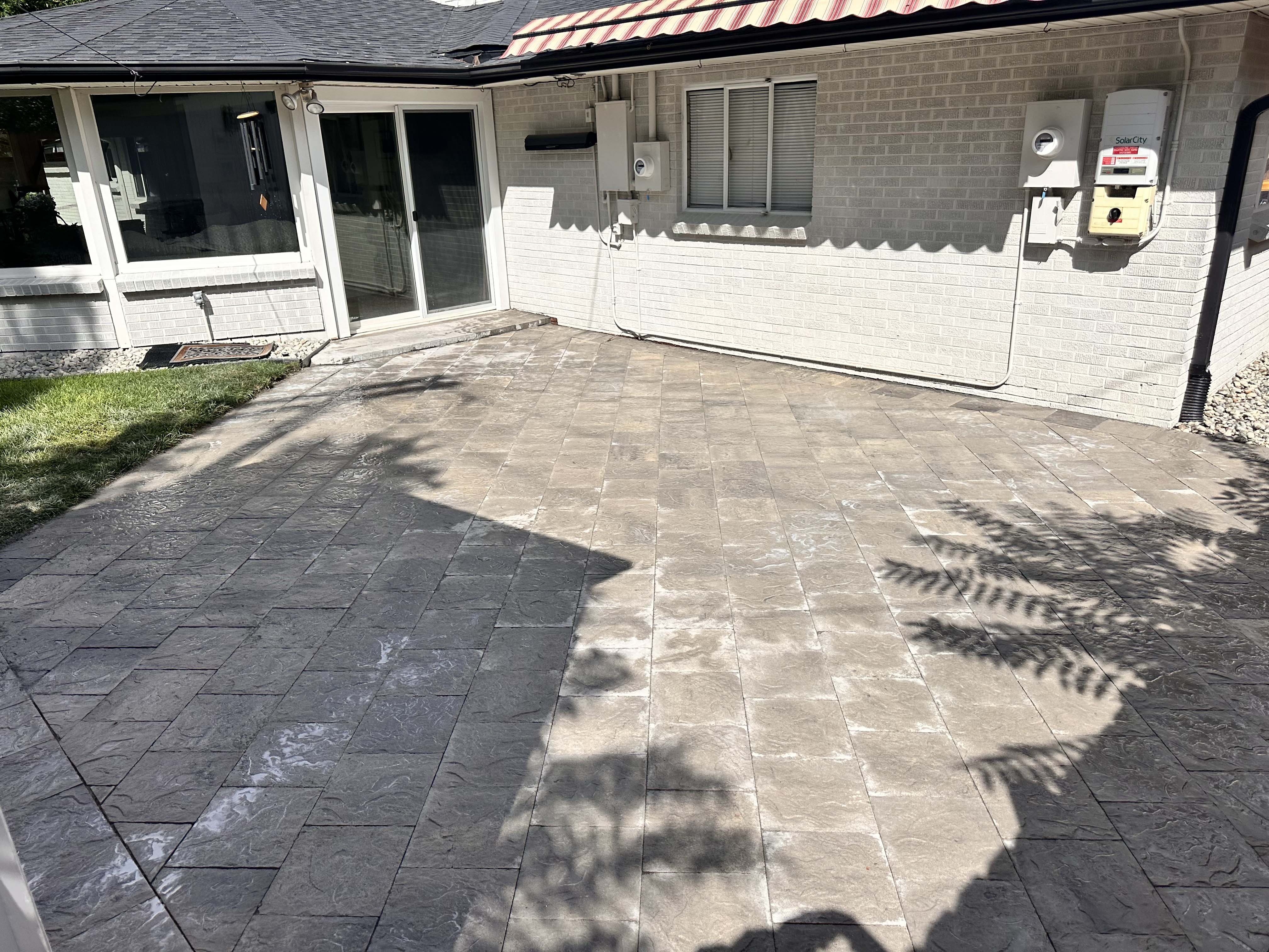 Paver patio behind a home by Grayscape Landscape & Design, a landscaper serving homeowners in Dallas County, TX