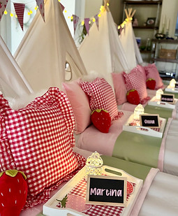 Strawberry themed teepee sleepover party setup with pink and gingham decor