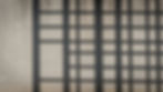 Grid pattern shadow on a light textured wall