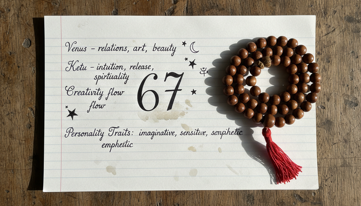 Top-down view of a journal page with the number 67 surrounded by simple numerology notes.
