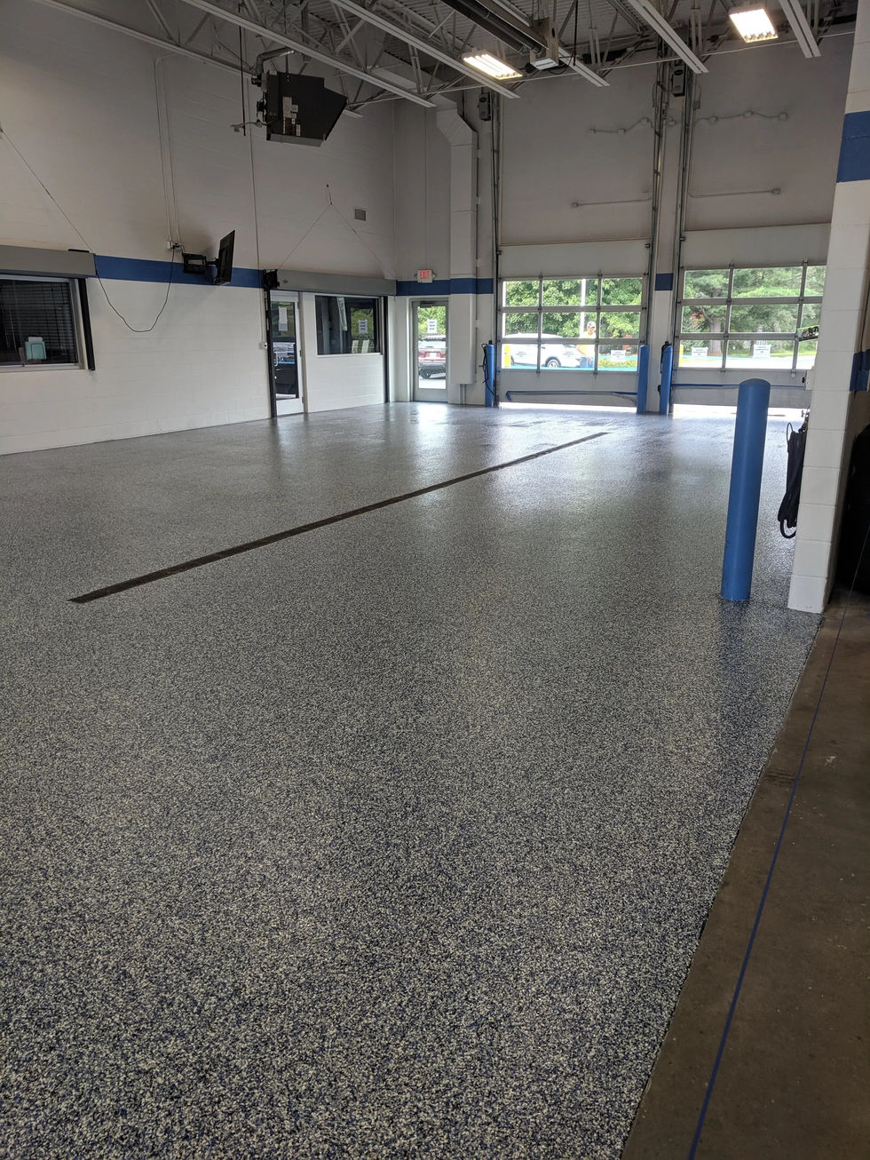 Automotive service center featuring commercial polyurea floor coating system installed by Armor Shield Concrete Coatings.