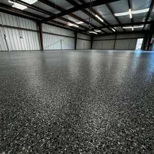 Industrial aircraft hangar floor finished with decorative flake polyurea concrete coating by Armor Shield Concrete Coatings.