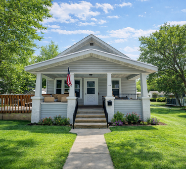 Light blue home with front porch and green lawn