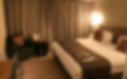 Contemporary hotel bedroom layout featuring a custom fluted timber headboard feature wall by Target Furniture.