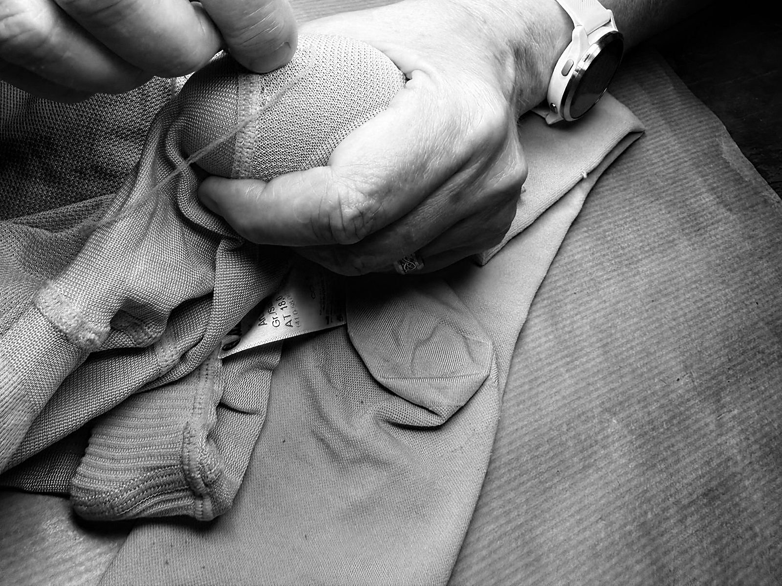 Reprise d'une maille sur un bas de contention, tenu dans la paume