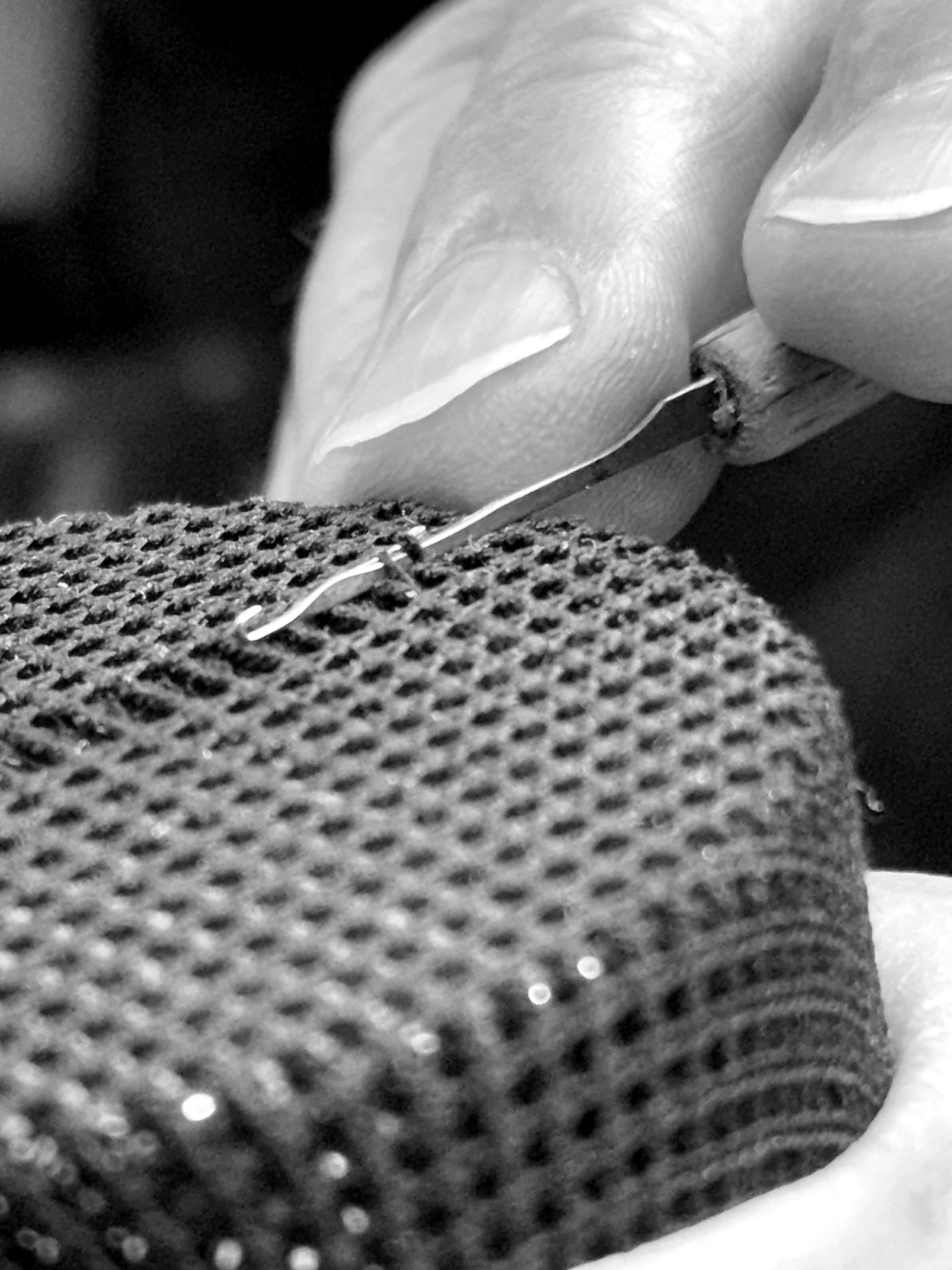 Gros plan du crochet à remailler engagé dans la maille