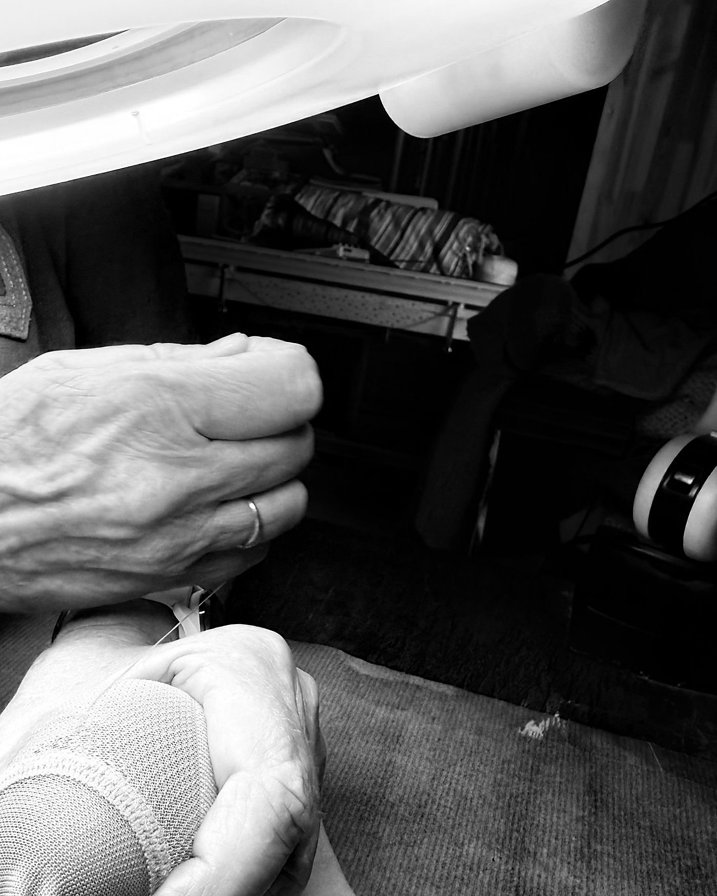 Les mains de Marika au travail sous la lampe loupe de l'atelier