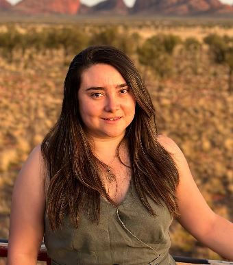 Woman smiling in a desert landscape with red mountains