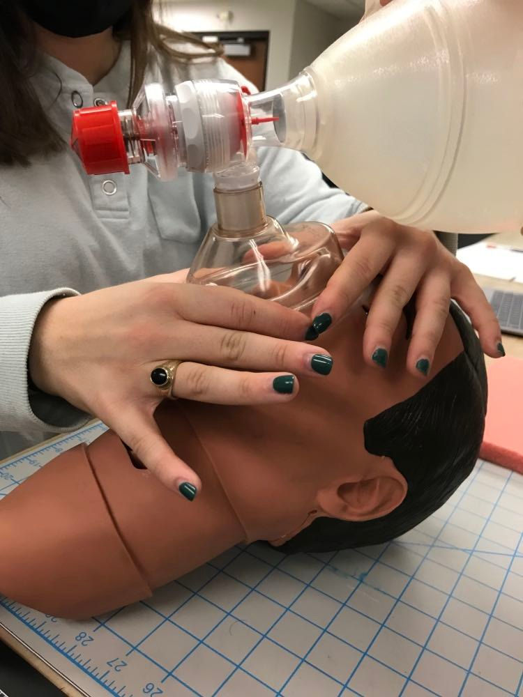 One person handling BVM face mask with 2 hands