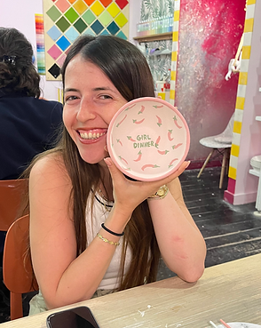 A girl showing her pottery at Clayla