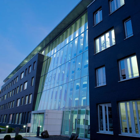 Architekt Korb Projekt – Modernes Bürogebäude mit großer Glasfassade und zeitgenössischer Architektur bei Abendlicht.